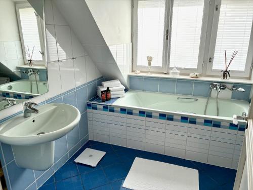 ein blau-weißes Bad mit einer Badewanne und einem Waschbecken in der Unterkunft Villa Riviera in Prag