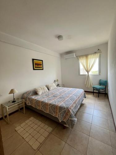 a bedroom with a bed and a window and a chair at Edificio Resistencia in Resistencia
