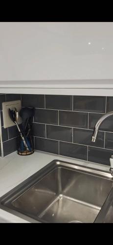 a stainless steel sink in a kitchen with a counter at Morris lodge in Kew
