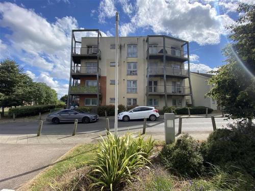 Un edificio con dos coches aparcados delante. en Morris lodge, en Dartford