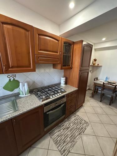 a kitchen with wooden cabinets and a stove top oven at NidoPorcari in Porcari
