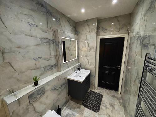 HanwellにあるLuxury 1BR Modern Flat in London W7 with Private Parkingのバスルーム(白いシンク、黒いドア付)