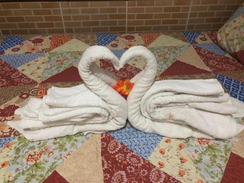 two swans made out of towels on a quilt at Pousada Tia Tita in Cayru