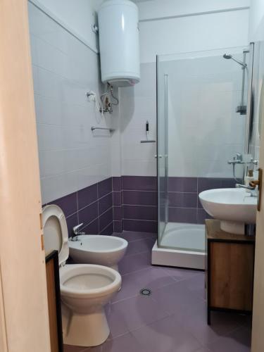 a bathroom with a toilet and a sink and a shower at Gjiri I Lalzit apartament in Durrës