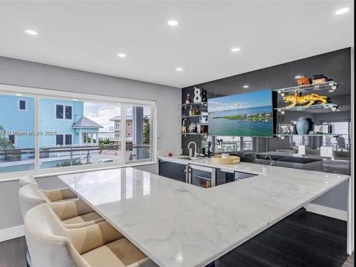 a kitchen with a large white marble table and chairs at Oceanfront Mansion With Boat & Jet Ski in Key Largo