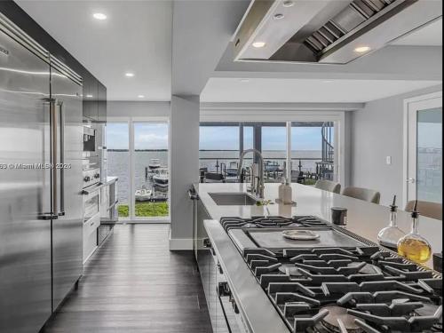 a kitchen with a stove and a view of the ocean at Oceanfront Mansion With Boat & Jet Ski in Key Largo