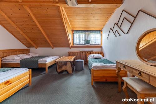 a room with three beds and a mirror at Dolina Rastoki in Koniaków