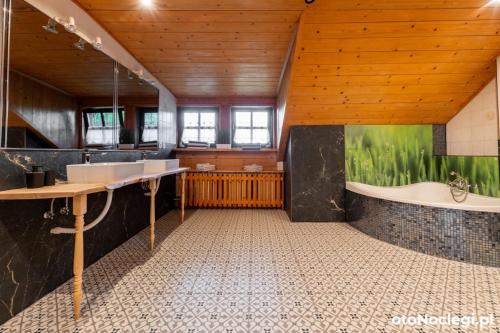a bathroom with two sinks and a bath tub at Dolina Rastoki in Koniaków