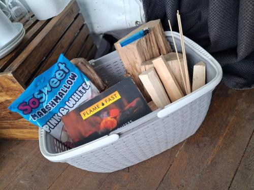 ein Korb voller Bücher und Bücher auf einem Tisch in der Unterkunft Secret Heated Dome, Hot Tub,Firepit Projector in Lincoln in Lincoln