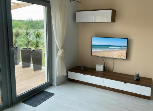 a living room with a flat screen tv on a wall at Casa Milo - Trzęsacz in Trzęsacz