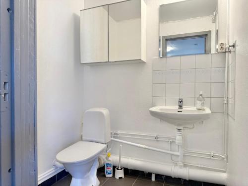 a white bathroom with a toilet and a sink at Worker & families Dream Apartment in the heart of Gothenburg in Gothenburg