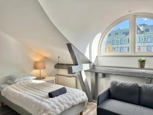 a bedroom with a bed and a window and a chair at Worker & families Dream Apartment in the heart of Gothenburg in Gothenburg