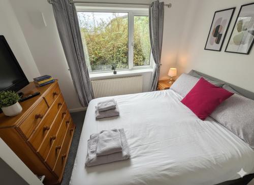 FlookburghにあるWillow Chalet near Cartmel & Lake Windermereのベッドルーム1室(赤い枕と窓付)