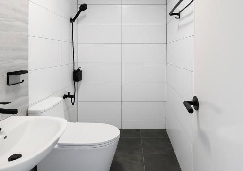 a white bathroom with a toilet and a sink at Balai de Biday 4 Pax Suite with Free Breakfast in Mameltac