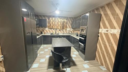 a kitchen with a counter and a chair in it at LOUNEL BnB in Kumasi