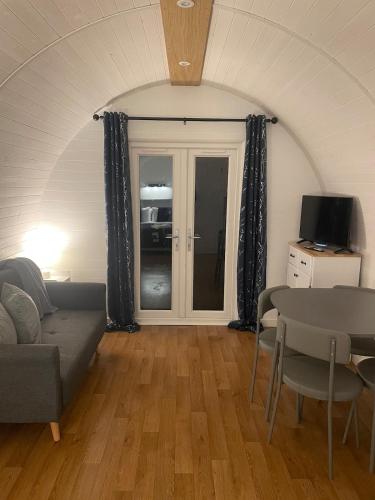 a living room with a couch and a table at AfonCoed - A cozy, quiet stay by the river in Llanrhaeadr-ym-Mochnant