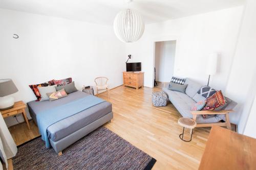 a living room with a bed and a couch at Modern design im klassischem Altbau in Weimar