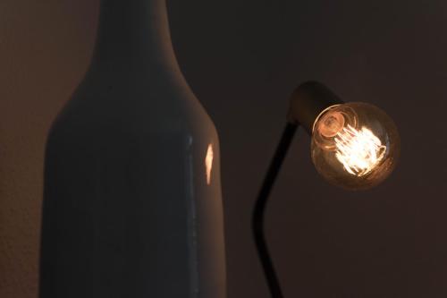a white bottle and a light next to a lamp at Modern design im klassischem Altbau in Weimar