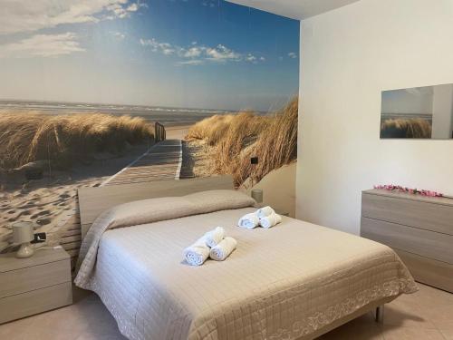 a bedroom with two beds and a painting of a beach at Baita Monte Caruso in Filiano