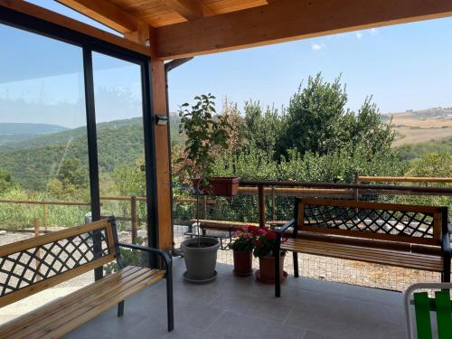 a porch with benches and a view of the mountains at Baita Monte Caruso in Filiano