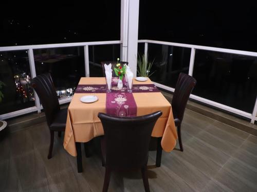 シレットにあるLa Vista Suites Sylhetのダイニングルーム(椅子付)が備わり、市街の景色を望めます。