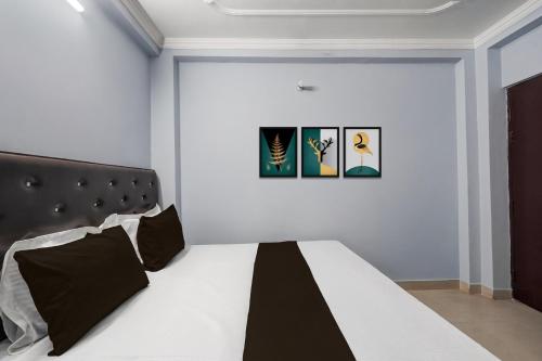a bedroom with a black and white bed with three paintings at Hotel O STAR GALAXY in Bhauli