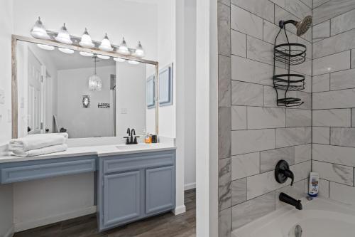 a bathroom with a tub and a sink and a mirror at Spacious Family Home in Round Rock w Private Yard in Round Rock