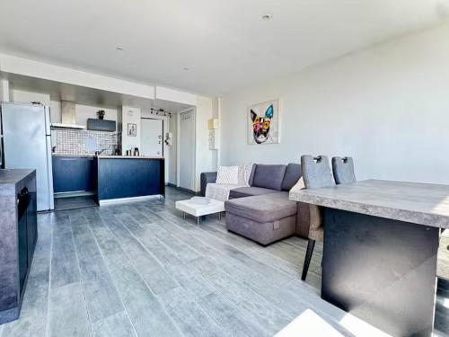 a kitchen and a living room with a couch at Apartment Paris La Défense Eiffel Tower Skyline in Puteaux