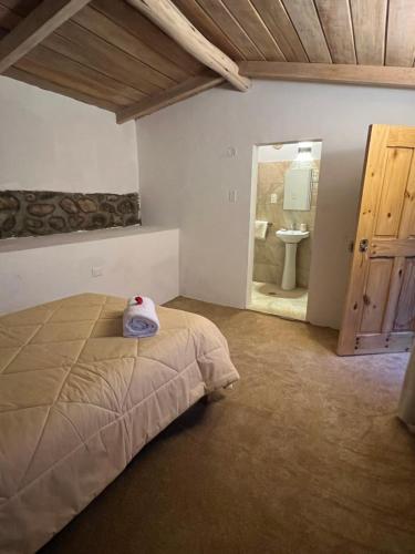 a bedroom with a bed and a bathroom with a sink at Mamá Raywa in Huari