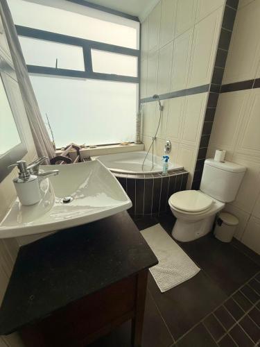 a bathroom with a sink and a toilet and a tub at Beachfront Apartment in Tergniet