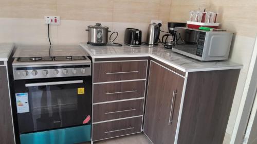 a kitchen with a stove and a microwave at Elilia in Beau Vallon