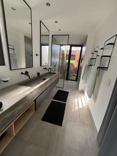 a bathroom with two sinks and a large mirror at Villa lagoon view Baie du cap bel ombre in Baie du Cap