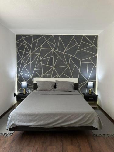 a bedroom with a large bed and two lamps at Brick House in Kragujevac