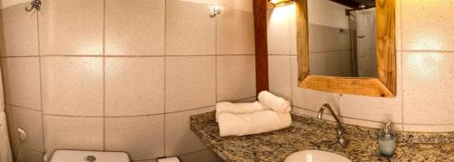 a bathroom with a sink and a toilet and a mirror at Casa Janjão in Icaraí
