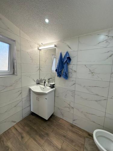 a white bathroom with a sink and a toilet at Brick House in Kragujevac