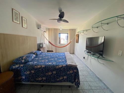 a bedroom with a bed and a flat screen tv at Apartamento amplo e confortavel in Cabedelo
