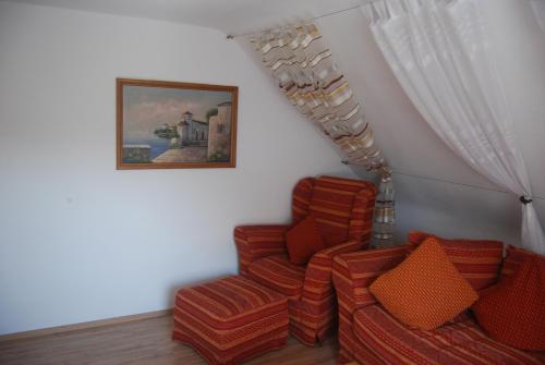 a room with two chairs and a painting on the wall at Ferienwohnung Cillien in Dudeldorf