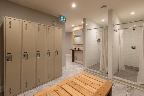 un baño con taquillas y ducha y una mesa de madera en Lóyly Spa Guesthouse, en Ottawa