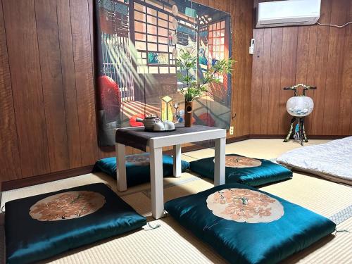 桜の宿 في أوساكا: غرفة بها طاولة وأربعة أكياس فول على الأرض