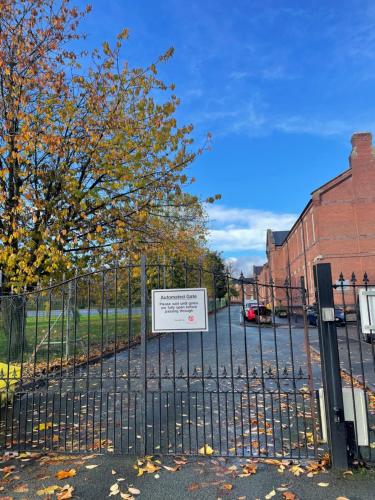 a sign on a fence in front of a building at Arti One Bedroom Apartment in Wrexham