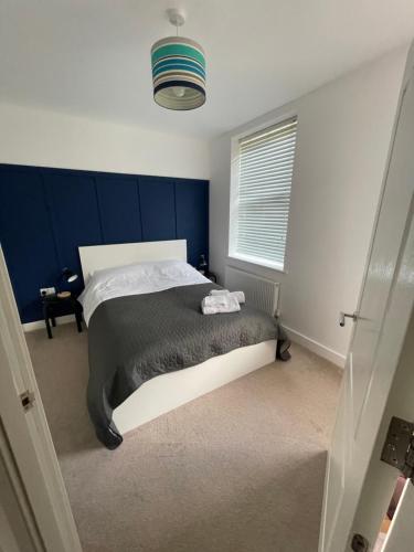 a bedroom with a bed with a blue wall at Arti One Bedroom Apartment in Wrexham