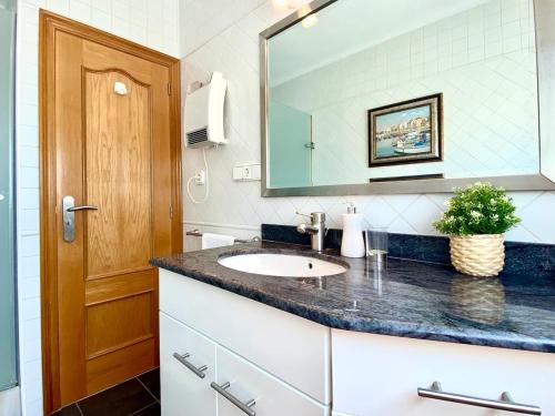 ein Badezimmer mit Waschbecken und Spiegel in der Unterkunft House in front of the beach in Cambrils