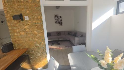 a living room with a couch and a brick wall at Superb luxury stay Croydon London in Thornton Heath