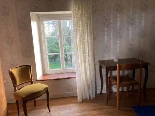 Una habitación con una mesa y sillas y una ventana. en Complete House with 6 bedrooms and life space, en Pont-Aven