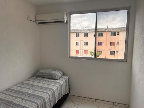 une petite chambre avec un lit et une fenêtre dans l'établissement Viver Melhor Apartment, à Marituba