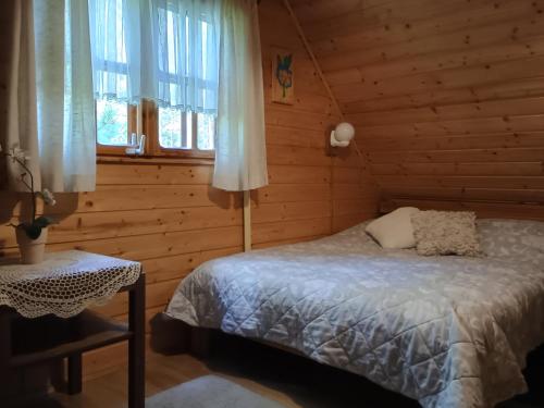 a bedroom with a bed in a log cabin at Sielski Zakątek in Piecki