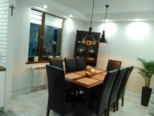 ein Esszimmer mit einem Holztisch und Stühlen in der Unterkunft Bieszczady Apartament Gniazdo Baligród in Baligród