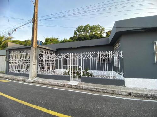 a white fence on the side of a building at House for rent in Residencial Santo Antônio in Belém