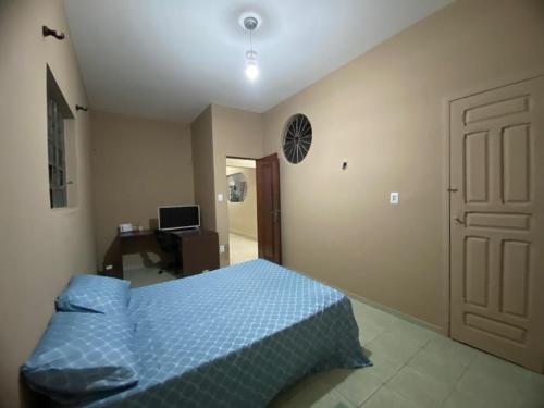 a bedroom with a bed and a desk and a door at House for rent in Residencial Santo Antônio in Belém