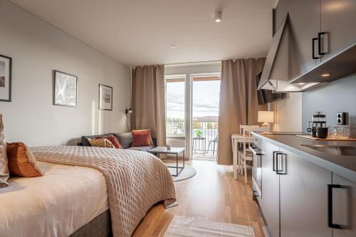 a hotel room with a bed and a kitchen at First Hotel Uppsala East in Uppsala